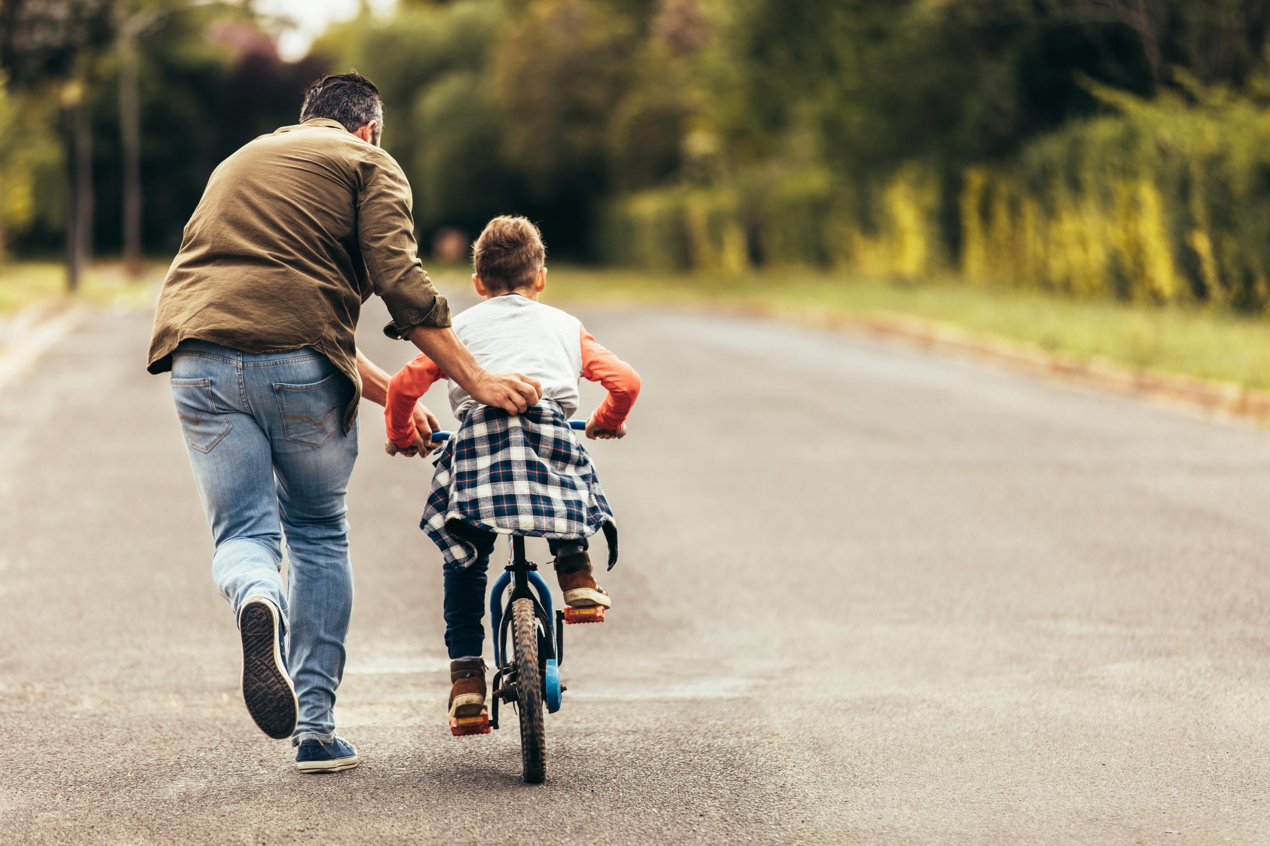 photo d'un père qui apprend à son enfant à faire du vélo