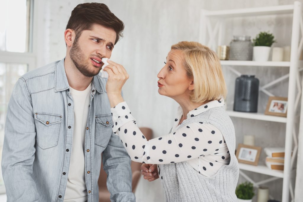 photo d'une mère couvant son fils jeune adulte