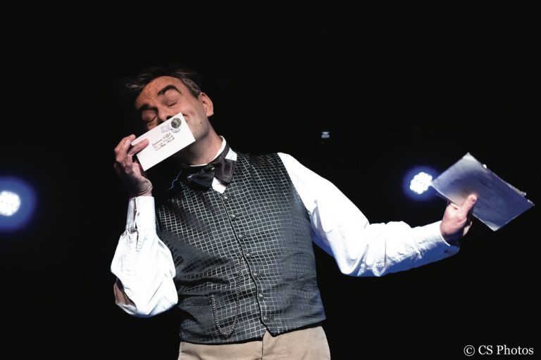 Photo représentant un homme tenant une enveloppe dans la main gauche et une lettre dans la main droite. Les yeux fermés il semble se réjouir de son contenu en la respirant.