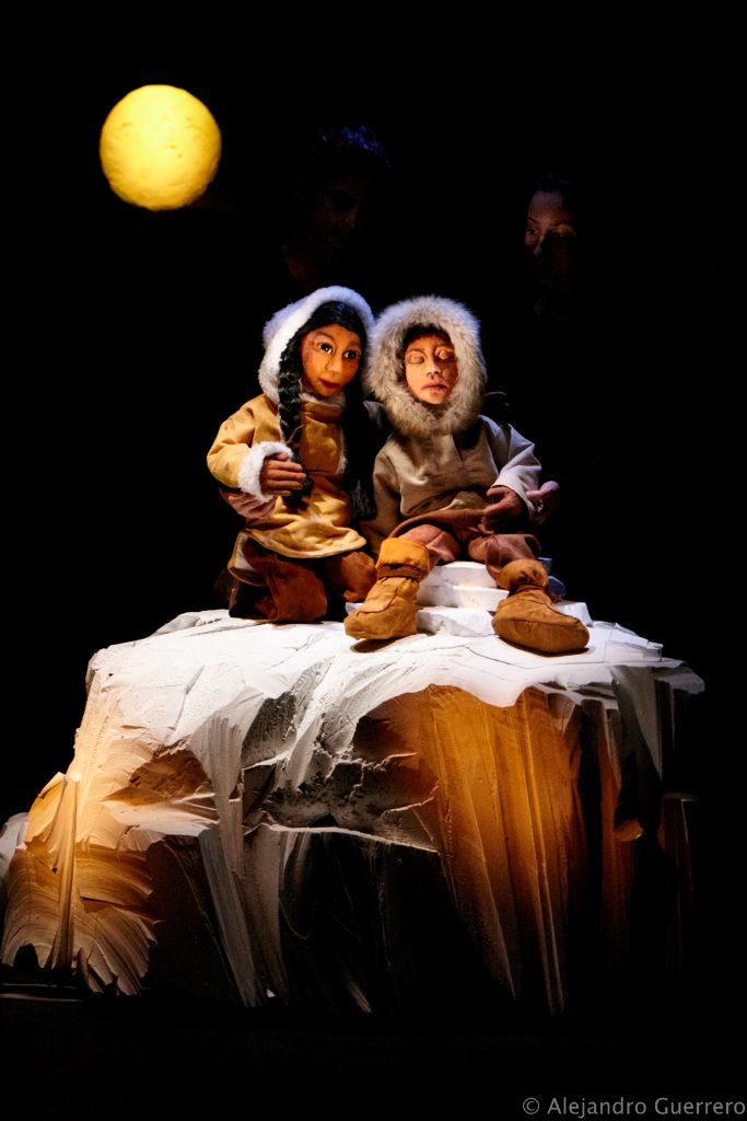 Photo représentant deux marionnettes à taille humaine : deux inuits assis dans la neige