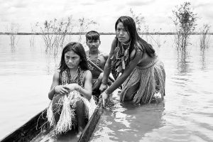 Photo représentant des membres d'une tribu amazonienne sur une barque