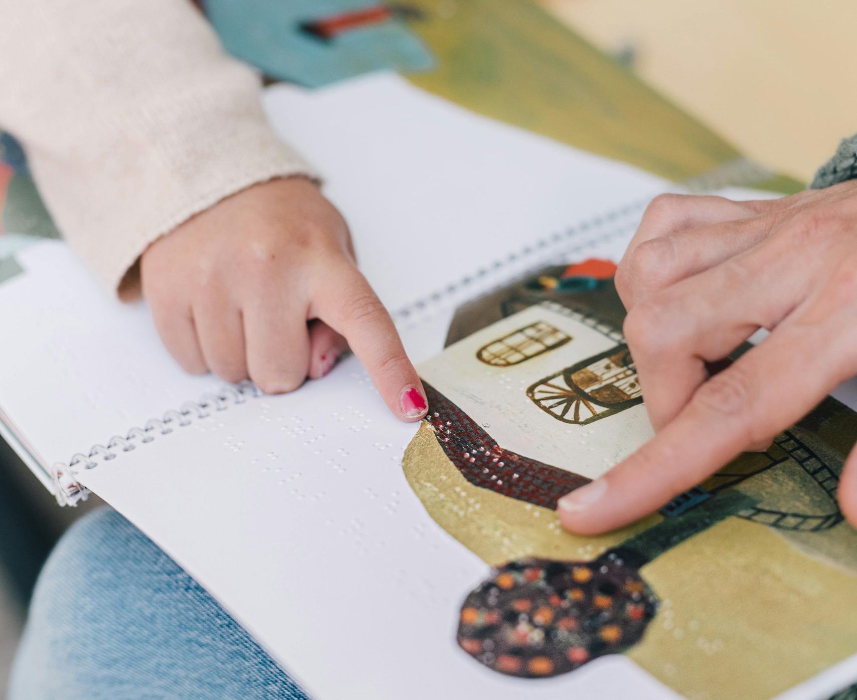 Photo représentant deux personnes en train de lire un livre en braille