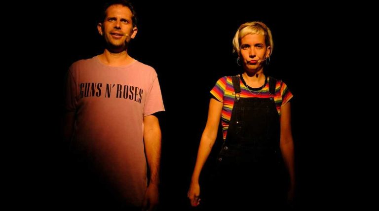 Photo représentant deux artistes sur scène, un homme et une femme en train de chanter avec des micros casques.