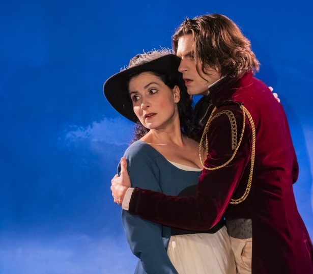 Photo représentant un homme et une femme en costume sur un fond de ciel bleu.