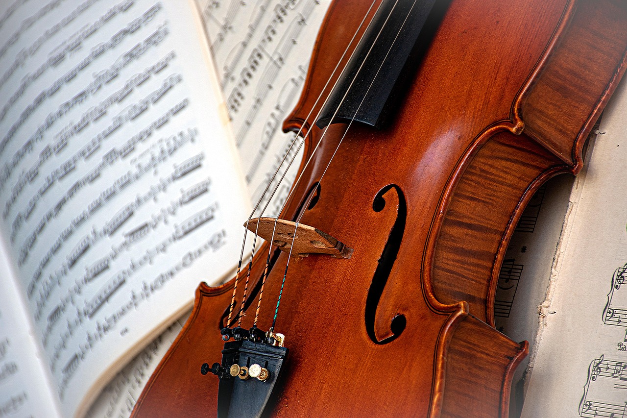 Photo représentant un violon posé à côté d'une partition.