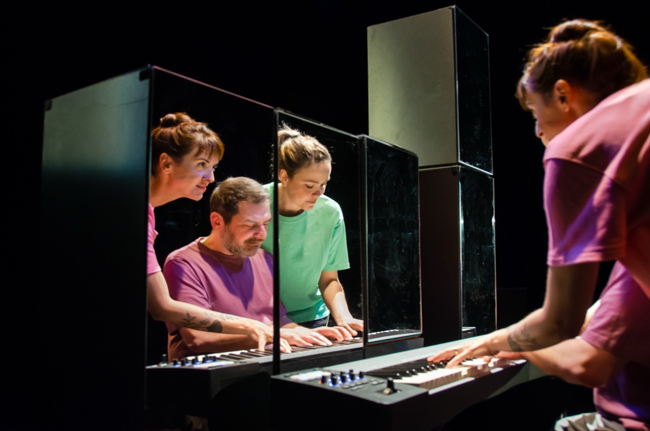 Photo représentant 3 musiciens au piano, deux femmes et un homme. Les deux femmes sont vêtues de tee-shirt rose et l'homme d'un tee-shirt vert.