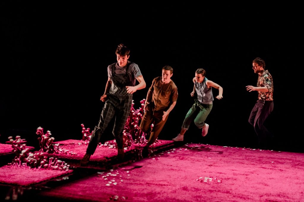 Photo représentant 4 danseurs en train de courir dans un décor complètement rose