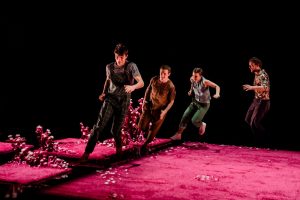Photo représentant 4 danseurs en train de courir dans un décor complètement rose
